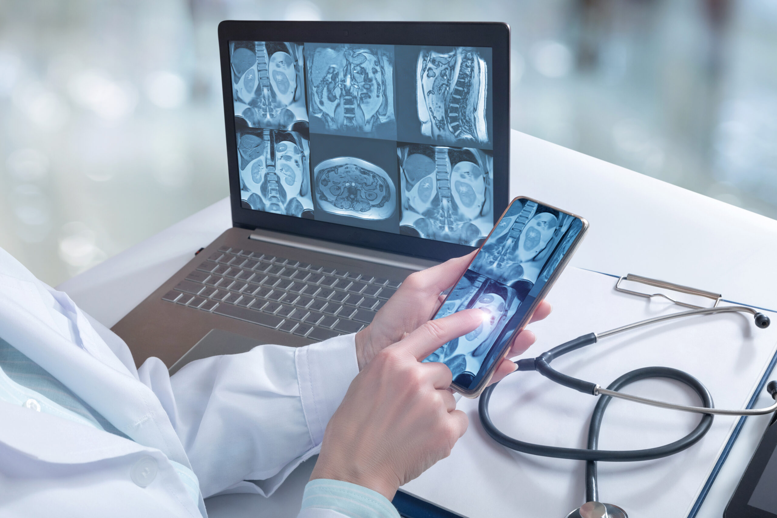 Doctor examines the internal organs of the patient on the computer and phone.